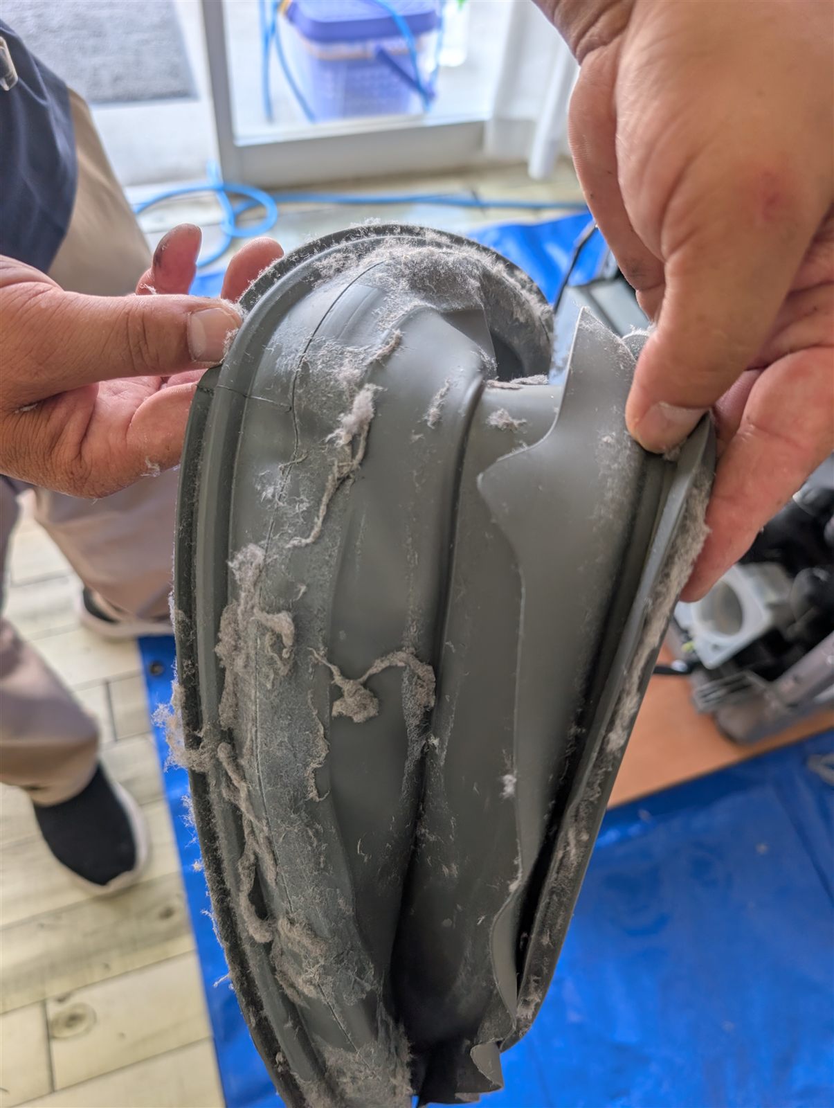 取り外した蛇腹状の排気ダクト部品 埃まみれで亀裂が入った状態